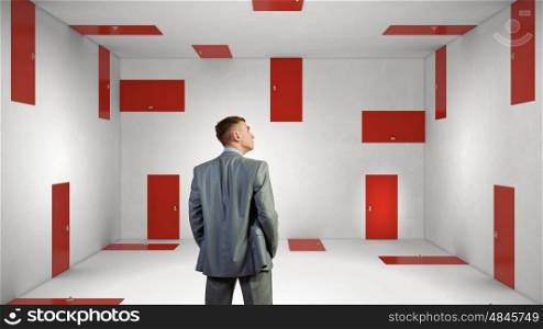 When making difficult decision. Businessman in room choosing one of plenty of doors