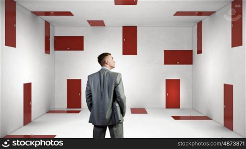When making difficult decision. Businessman in room choosing one of plenty of doors