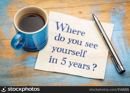 Where do you see yourself in 5 years? Handwriting on a napkin with a cup of espresso coffee