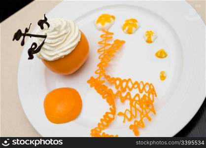 whipped cream with chocolate anchor in an orange served with orange caramel spirals