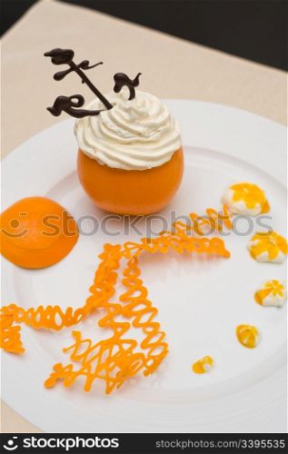 whipped cream with chocolate anchor in an orange served with orange caramel spirals