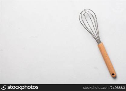 Whisk cooking egg beater mixer whisker new clean with wooden handle on stucco table top view