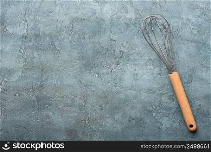 Whisk on cooking table background top view with copy-space.