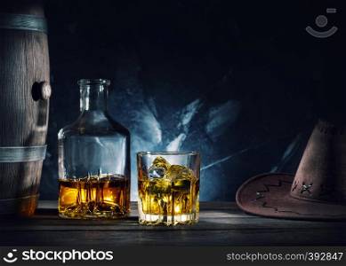 Whiskey and hat and barrel on dark marble background. Whiskey and hat and barrel on dark background