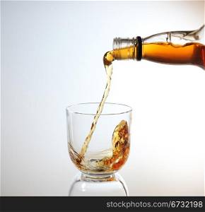 whiskey being poured into a glass