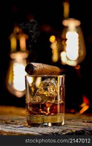 Whiskey in glass and cigar on wooden table. Whiskey and cigar
