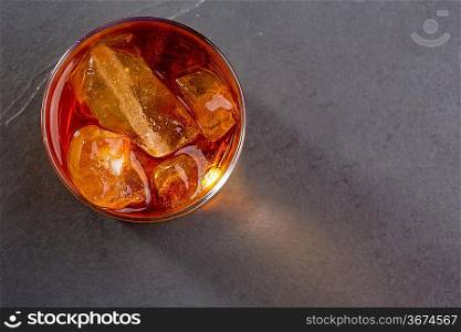 Whiskey whisky on the rocks on glass over gray black background