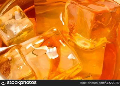 Whiskey with ice background close up