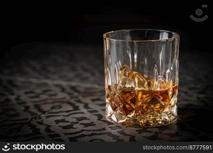 Whiskey with ice in glass on dark background, copy space. Whiskey with ice in glasses