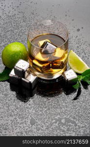 Whiskey with steel cooling cubes on dark glass background.. Whiskey with steel cooling cubes on dark glass background