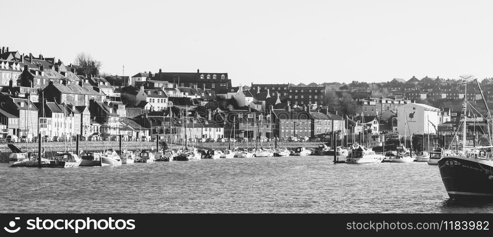 Whitby, North Yorkshire, England - Jan 28, 2019:,UK - Black and white photo of The harbour at Whitby on the North Yorkshire coast, Fishing boats tied up to the quay in Whitby harbour