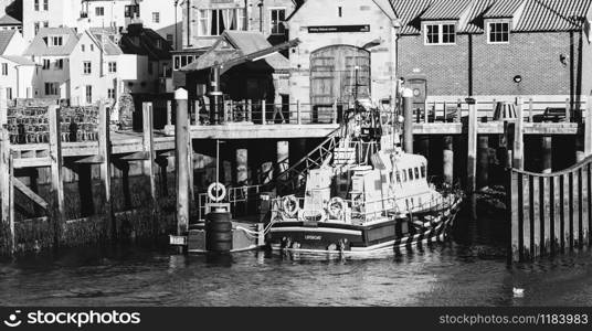 Whitby, North Yorkshire, England - Jan 28, 2019:,UK - Black and white photo of The harbour at Whitby on the North Yorkshire coast, Fishing boats tied up to the quay in Whitby harbour