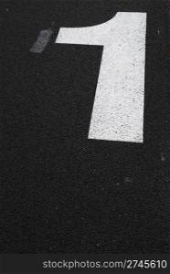 white 1 number sign painted on the asphalt road