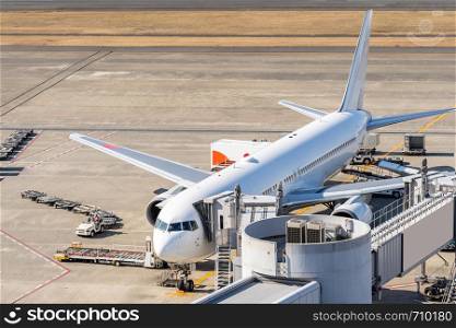 White Airplane unloading and loading passenger at Jet bridge in airport