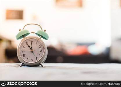 White alarm clock on the bed, morning, copyspace, wake up time