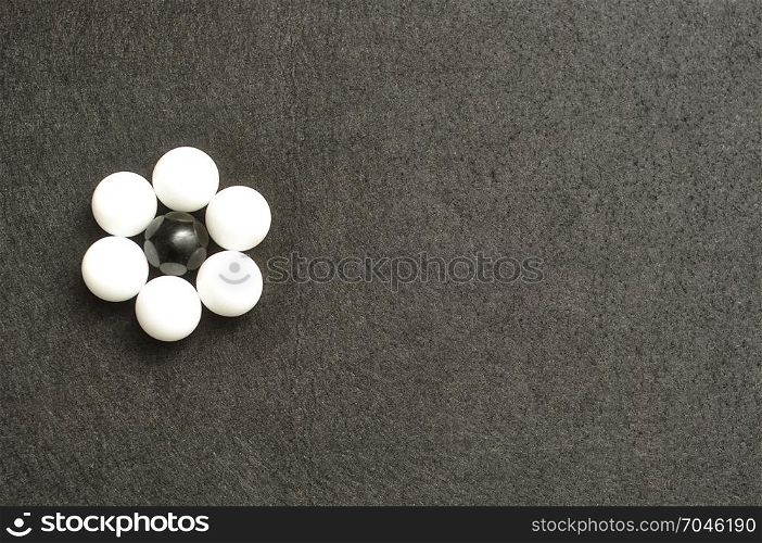 White and black balls packed in the shape of a flower isolated on a black background