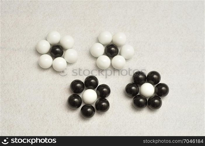 White and black balls packed in the shape of a flowers isolated on a white background