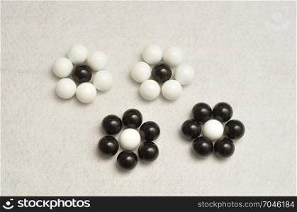 White and black balls packed in the shape of a flowers isolated on a white background