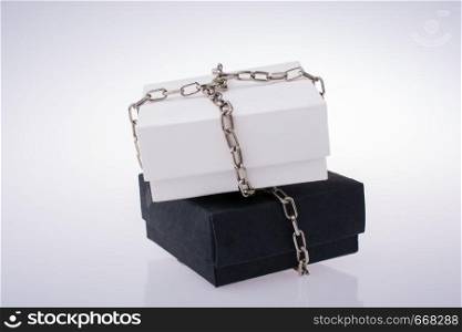 White and black gift boxes with chains on a white background