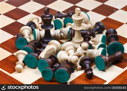 white and black kings in middle of scattered chess pieces on chessboard