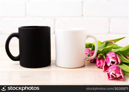 White and black mug mockup with magenta pink tulips bouquet . White and black mug mockup with rich magenta pink tulips bouquet near painted brick wall. Empty mug mock up for design promotion