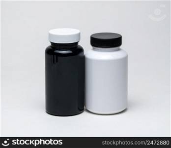 White and black plastic pill jars on a white background. Isolated. plastic pill jars