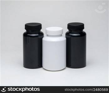 White and black plastic pill jars on a white background. Isolated. plastic pill jars