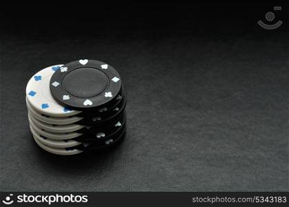 White and black poker chips on a black background