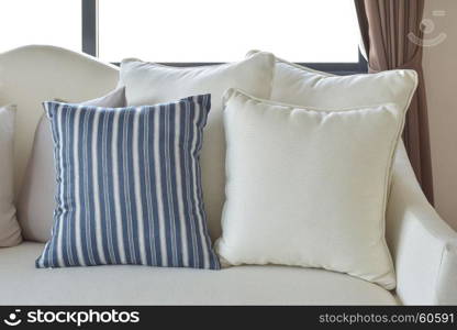 white and blue decorative pillows on a casual sofa in the living room