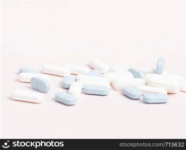 White and blue pills on a white, highly contrasting background. White and blue tablets on a white, highly contrasting background