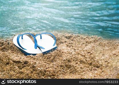 white and blue sandal on the sand beach, Summer holiday and vacation concept.