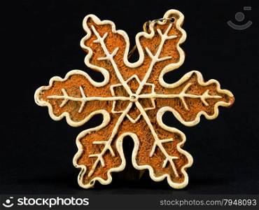 white and brown Christmas ornament, snow flake against black background