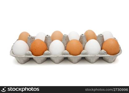White and brown eggs in a paper box in a chessboard order isolated