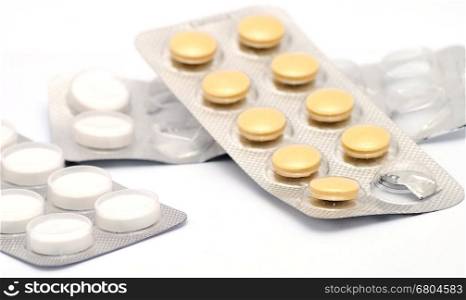White and brown pills in opened boxes placed on white background.