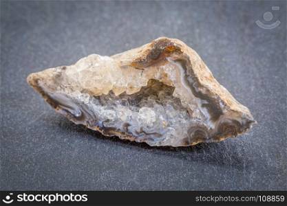 white and gold quartz geode against gray slate stone