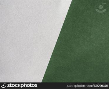 white and green paper texture background. white sheet of paper over green leatherette texture useful as a background - focus on paper