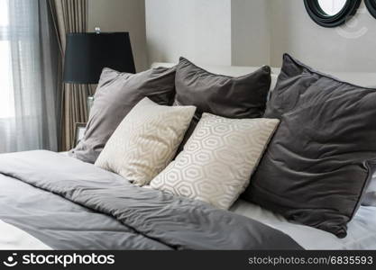 white and grey pillows on bed in modern bedroom