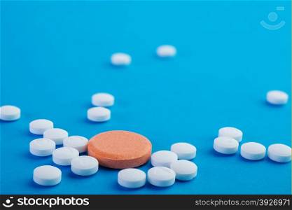 white and orange pills on a blue background