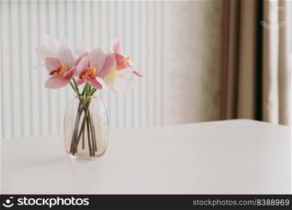 White and pink orchids in vase on white table. Copy space