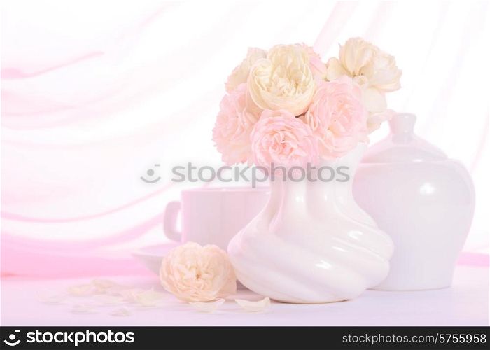 White and pink roses in a vase on pink background closeup
