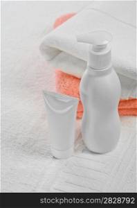 White and pink towels tube and bottle