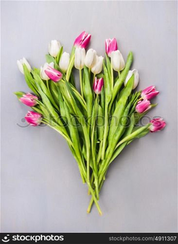 white and pink tulips Bouquet on gray wooden background , top view