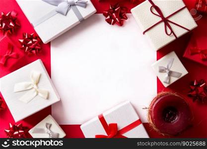 White and red gift on red background with paper card for text. Christmas concept