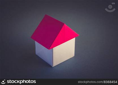 White and red paper house origami isolated on a grey background.. White and red paper house origami isolated on grey background