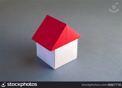 White and red paper house origami isolated on a grey background.. White and red paper house origami isolated on grey background