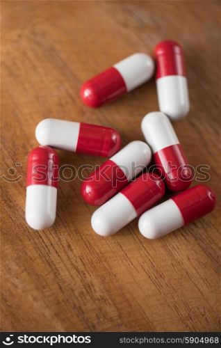 White and red pills . White and red pills on wooden background.