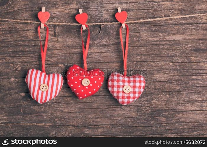 White and red sewed christmas hearts attached to the rope. Holiday background for greetings Valentine&rsquo;s day