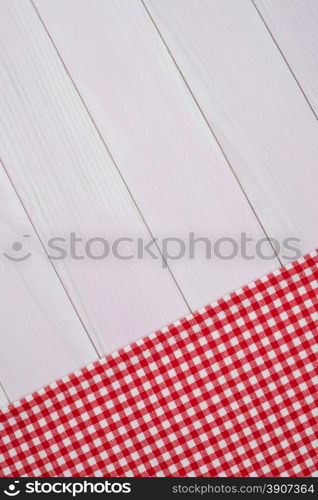 White and red towel over wooden kitchen table. View from above.