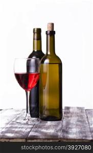 White and red wine without label and wine glass on rough boards