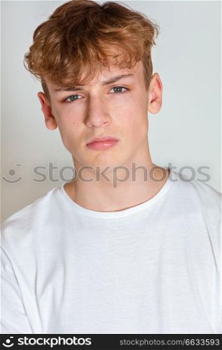 White background studio photograph of young boy male teen teenager young adult looking sad, thoughtful or depressed